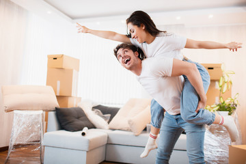 H appy husband and wife have fun swirl sway relocating to own apartment together, relocation concept. Overjoyed young couple dance in living room near cardboard boxes entertain on moving day.
