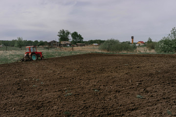 Before planting potatoes, a tractor plows the land in the village on a may day | KOROVYAKOVA, SVERDLOVSKAYA OBLAST - 9 MAY 2020.