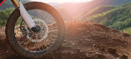 Part of a motocross wheel on a mound, with sunrise.copyspace for your individual text