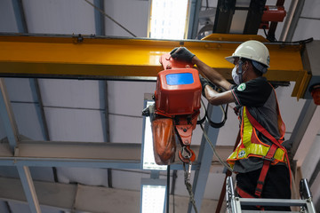 Engineers are inspecting hooks for lifting safety crane steel In the factory auto parts license Crane Operation
