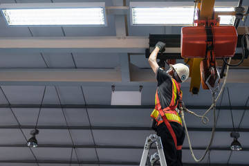Engineers are inspecting hooks for lifting safety crane steel In the factory auto parts license...