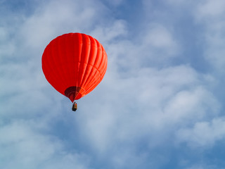 Red hot air balloon flying in the blue sky over Cappadocia. Travel by air balloon.