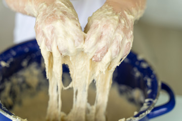 Baby kneads dough in a saucepan