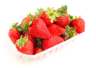 fresh appetizing strawberries in a plastic tray onwhite background