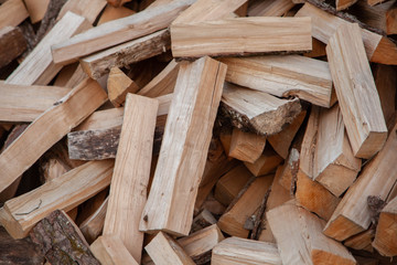 Trees in the sawmill are stacked in bags for sell. Stacks of firewood. Preparation of firewood for the winter. A heap of woodpile. Chopped wood. Firewood.Pile of wood logs ready for winter
