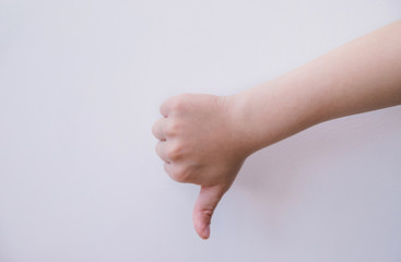 A child's hand shows a thumbs-down gesture on a white background.