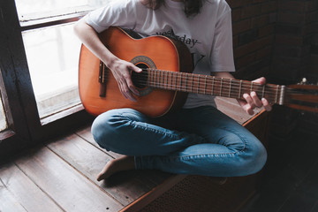Playing the retro guitar. Girl plays guitar