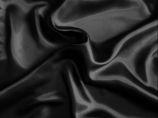 Fototapeta premium Black glossy crumpled fabric. Wavy fluid background