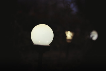 Decorative solar lamp. Charging solar lamp on the ground in the garden at night, renewable energy concept