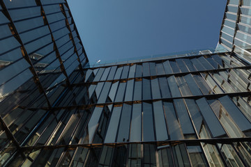 glass facades of modern office buildings and reflection of blue sky 