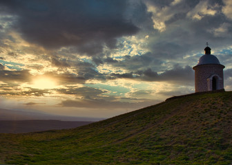 Picturesque chapel in the middle of vineyard's fields at the sunset time.