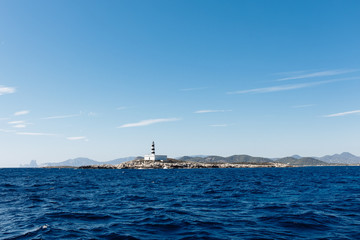 Obraz premium Lighthouse on the sea under sky.