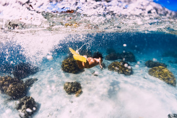 Fototapeta na wymiar Woman swimming underwater with yellow fins in ocean. Freediving or snorkeling in Mauritius
