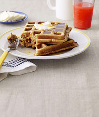 a plate of waffle with cream on a top