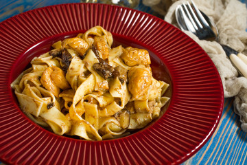 Tagliatelle pasta with chicken and boletus mushrooms.