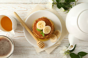 Composition with pancakes on white wooden background, top view. Sweet breakfast