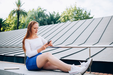 Young woman messaging on smartphone on street