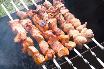 Traditional skewers on skewers and barbecue. Springtime outdoor recreation. Grilled meat.