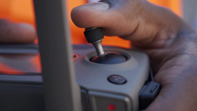 A close-up shot of a Black commercial drone pilot using the controls.