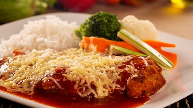 Slide shot meat Parmigiana with cheese and vegetables. Smoke.