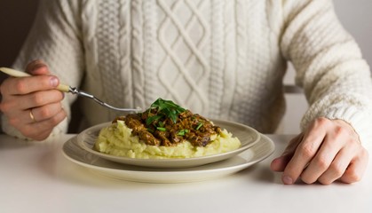 Man eating with fork the beef stroganoff and mashed potatoes