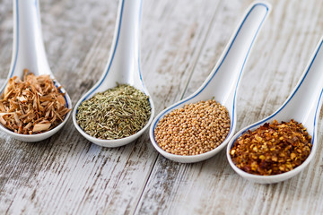 Spices and herbs in porcelain spoons