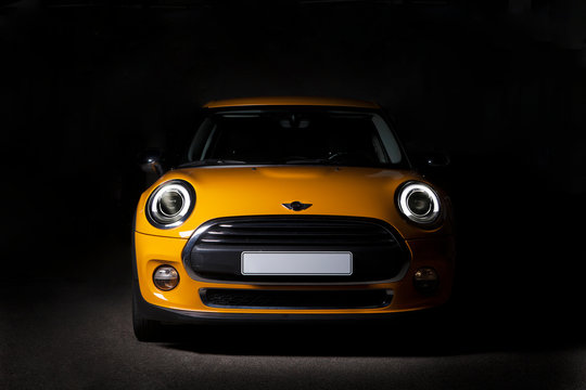 Nuova Mini 5 porte di colore giallo senape metallizzato isolata su sfondo nero