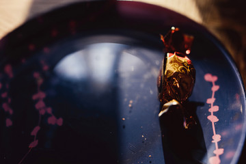 chocolate bright candy on a plate beautiful dish with a red pattern dark background and rays of light