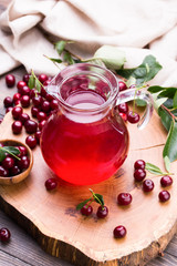 Glass of cherry juice on wooden background
