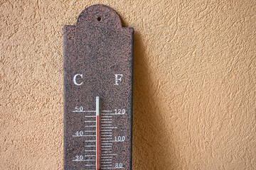 Rustic outdoor weather thermometer measuring/record an extreme heatwave, close up of vintage garden thermometer showing a very high temperature almost 120 Fahrenheit, 50 degrees celsius with copyspace