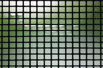 Metal mesh with water drops on a colorful background