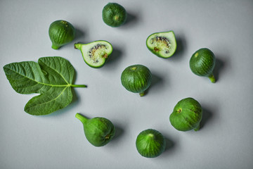 Green common fig with a leaf on grey background