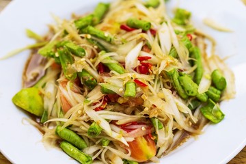 Close up of (Som Tum) spicy green papaya salad thai street food market