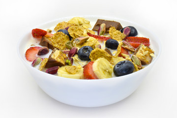 Corn flakes with fresh Fruit, Pistachio and chocolate in bowl, isolated on white background