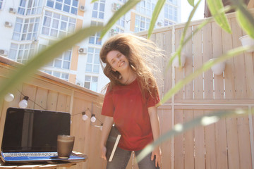 girl at home on the balcony dancing and studying on a Sunny day