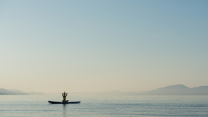 Young woman exercising on sup board