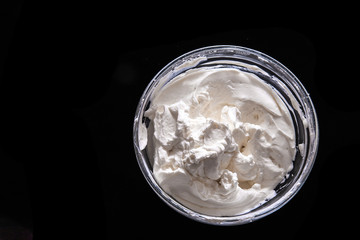 Kneading dough for buns. The dough is whipped in a glass bowl. Black background. Space for text.