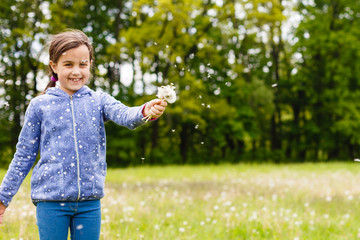 Cute little girl on the meadow in summer day