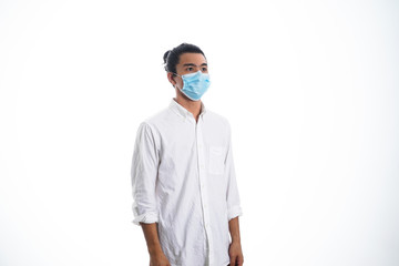 An Asian young man isolated on white background with casual entire and wearing a face mask. Hand gesture stop, sick, respect. during corona virus 