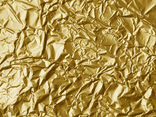 Crumpled metallic gold foil texture background