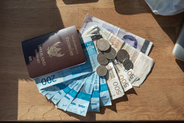 Currency Norway Kroner banknote with Coins and Thailand Passport on the table