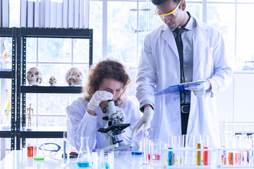 Beautiful young scientist biologists or researchers putting personal protective equipments to...