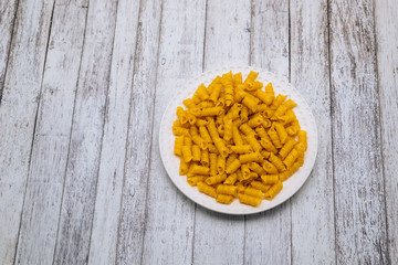 Dry pasta in the form of a spiral on a white plate.