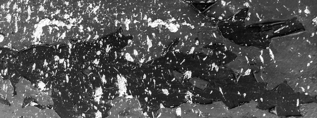 Black and white picture who depicts black mountains under the snow at night.