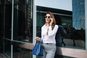 Trendy businesswoman chatting on phone in downtown