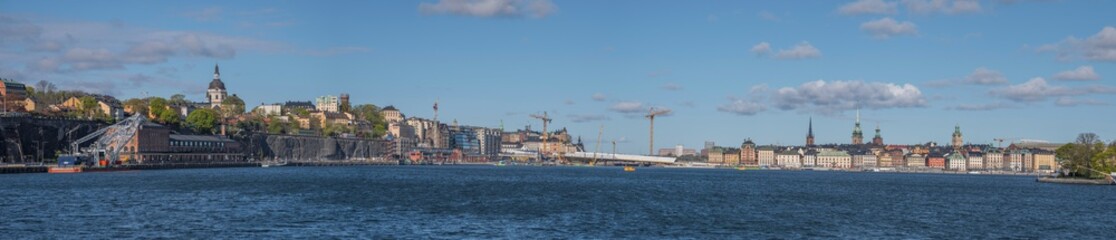 Fototapeta na wymiar Skyline over the districts of Södermalm and the old town Gamla Stan at the sluice building with the golden bridge in Stockholm a sunny spring day.