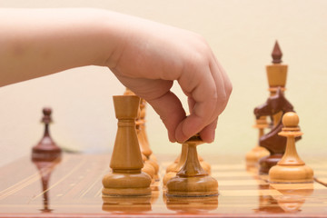 the children's hand puts a chess figure on the game field