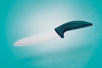 ceramic kitchen knife on blue background