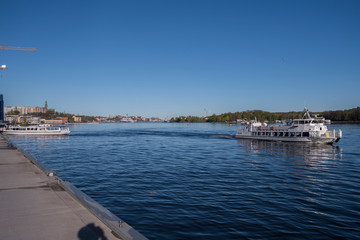 Fototapeta premium Nacka Strand harbor view with boats and monument in the district Nacka a sunny spring morning in Stockholm.