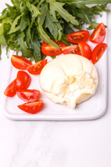 Burrata cheese, sliced tomato and arugula.